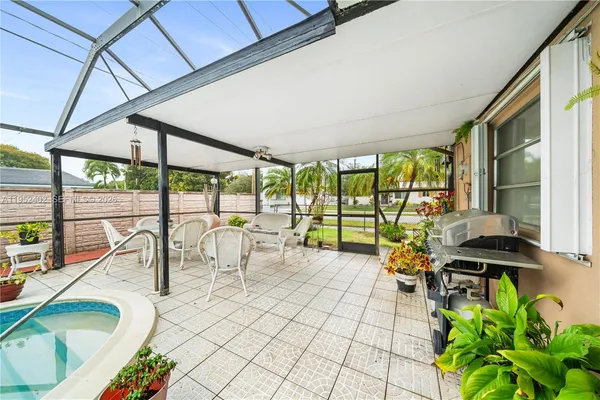 a living room with patio furniture and a floor to ceiling window