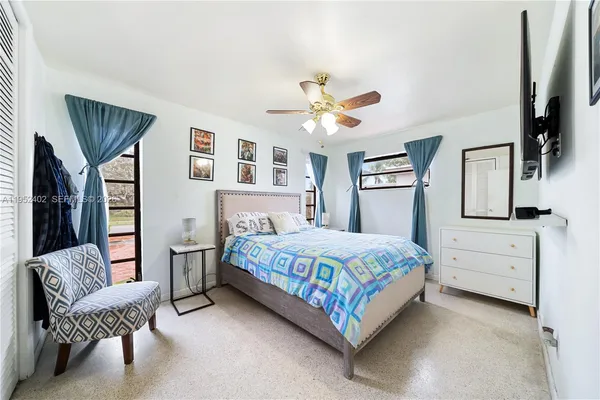 a bedroom with a bed chandelier and a window