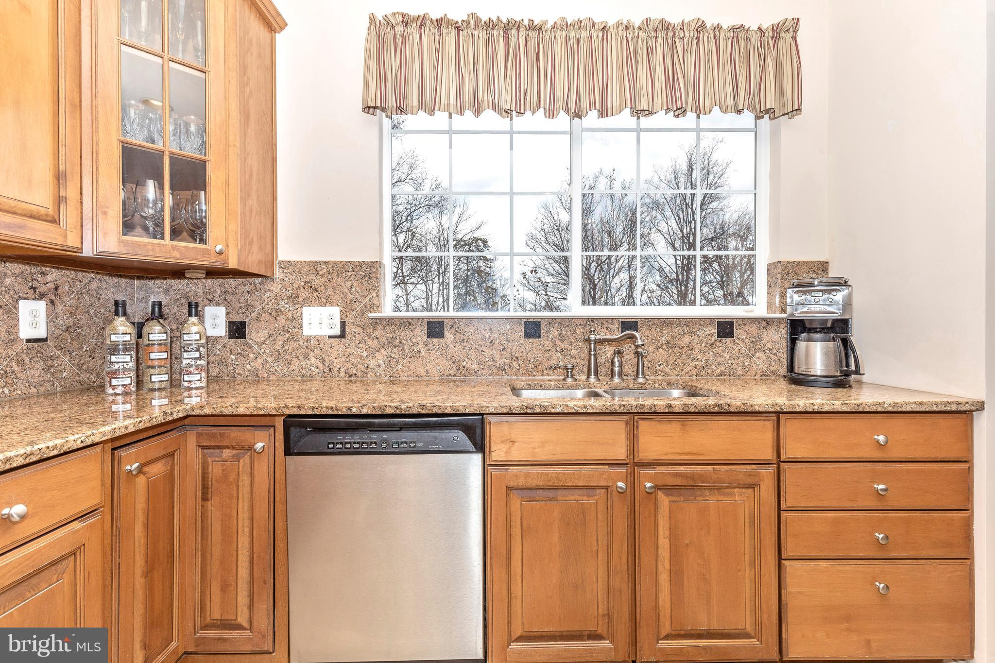 14513 Bubbling Spring Road Boyds, MD 20841 - Photo 13 of 57 a kitchen with granite countertop white cabinets and a window