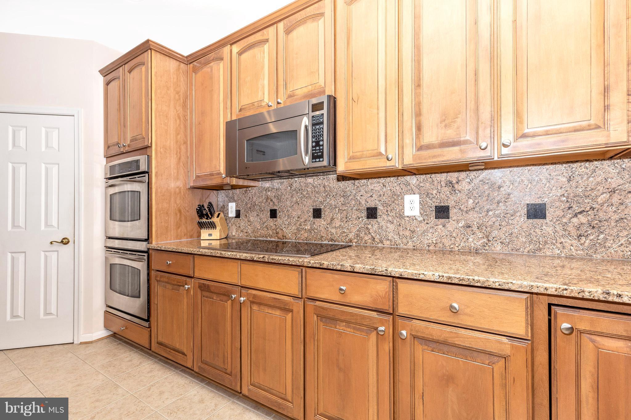 14513 Bubbling Spring Road Boyds, MD 20841 - Photo 16 of 57 a kitchen with stainless steel appliances granite countertop white cabinets and a sink