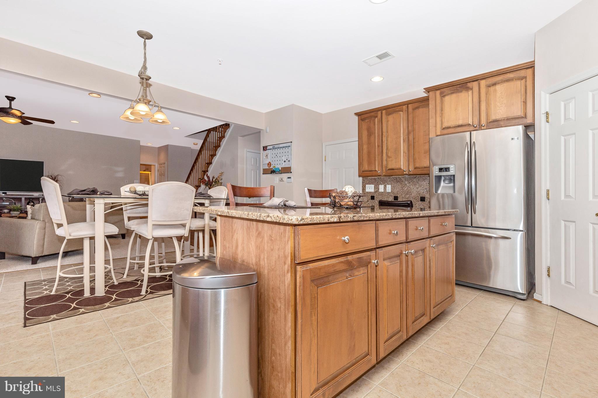 14513 Bubbling Spring Road Boyds, MD 20841 - Photo 17 of 57 a kitchen with stainless steel appliances granite countertop a refrigerator a stove a sink dishwasher and white cabinets with wooden floor