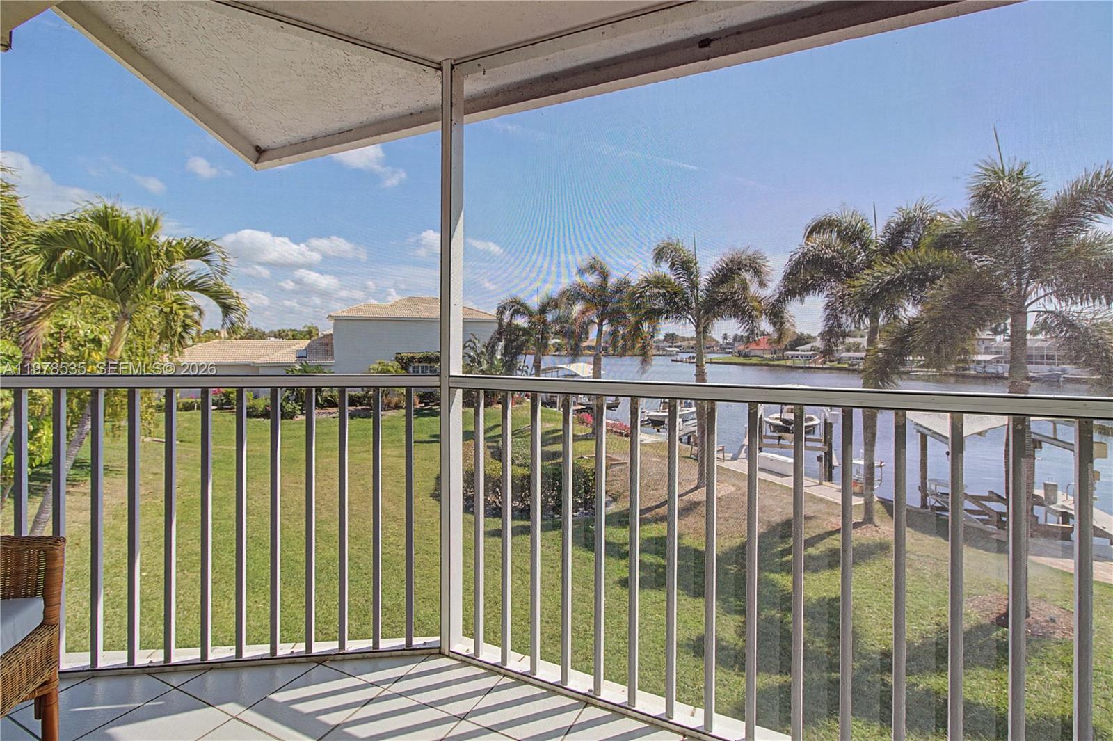 140 Eveningstar Cay Naples, FL 34114 - Photo 20 of 51 a view of a balcony with floor to ceiling window and wooden fence
