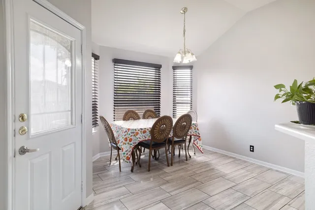 a dining room with furniture potted plants and wooden floor