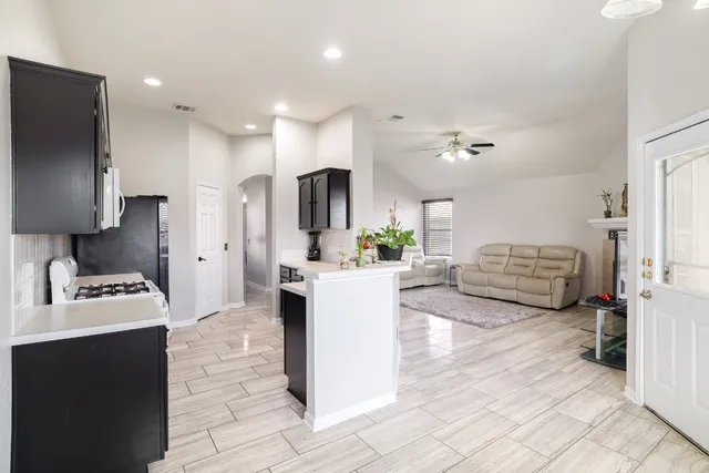 a large white kitchen with a refrigerator a stove a sink and a cabinets