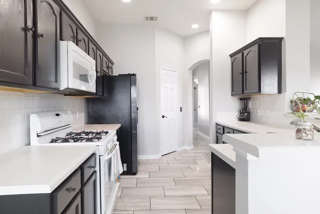 a kitchen with stainless steel appliances a stove a sink and a refrigerator