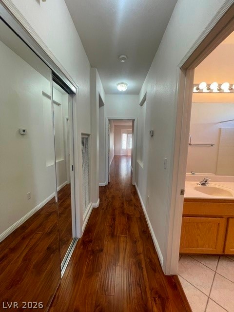 3047 Hickory Valley Road Henderson, NV 89052 - Photo 11 of 21 Rich hardwood-style flooring extends through this well-lit hallway leading to a bright, functional bathroom.