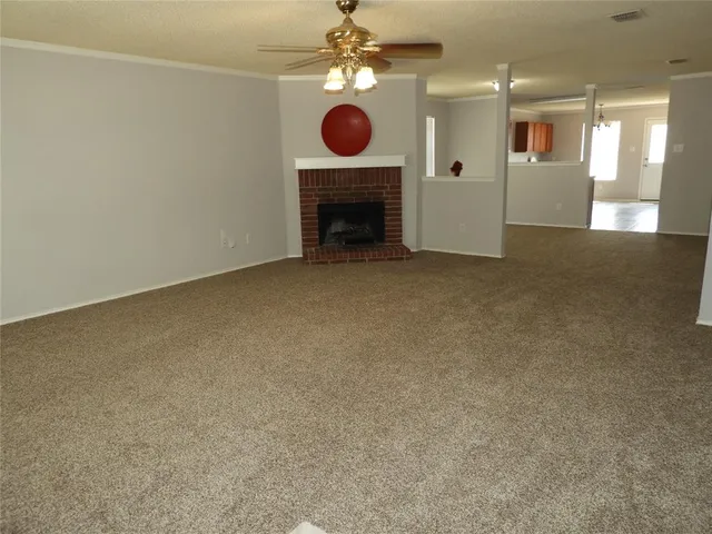 a view of an empty room with a fireplace and fan
