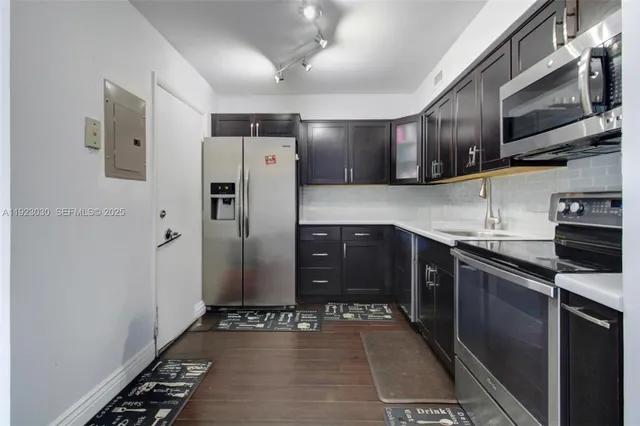 a kitchen with stainless steel appliances granite countertop a refrigerator and a sink