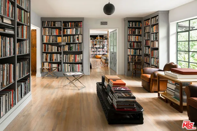 a living room with furniture a flat screen tv and a floor to ceiling window