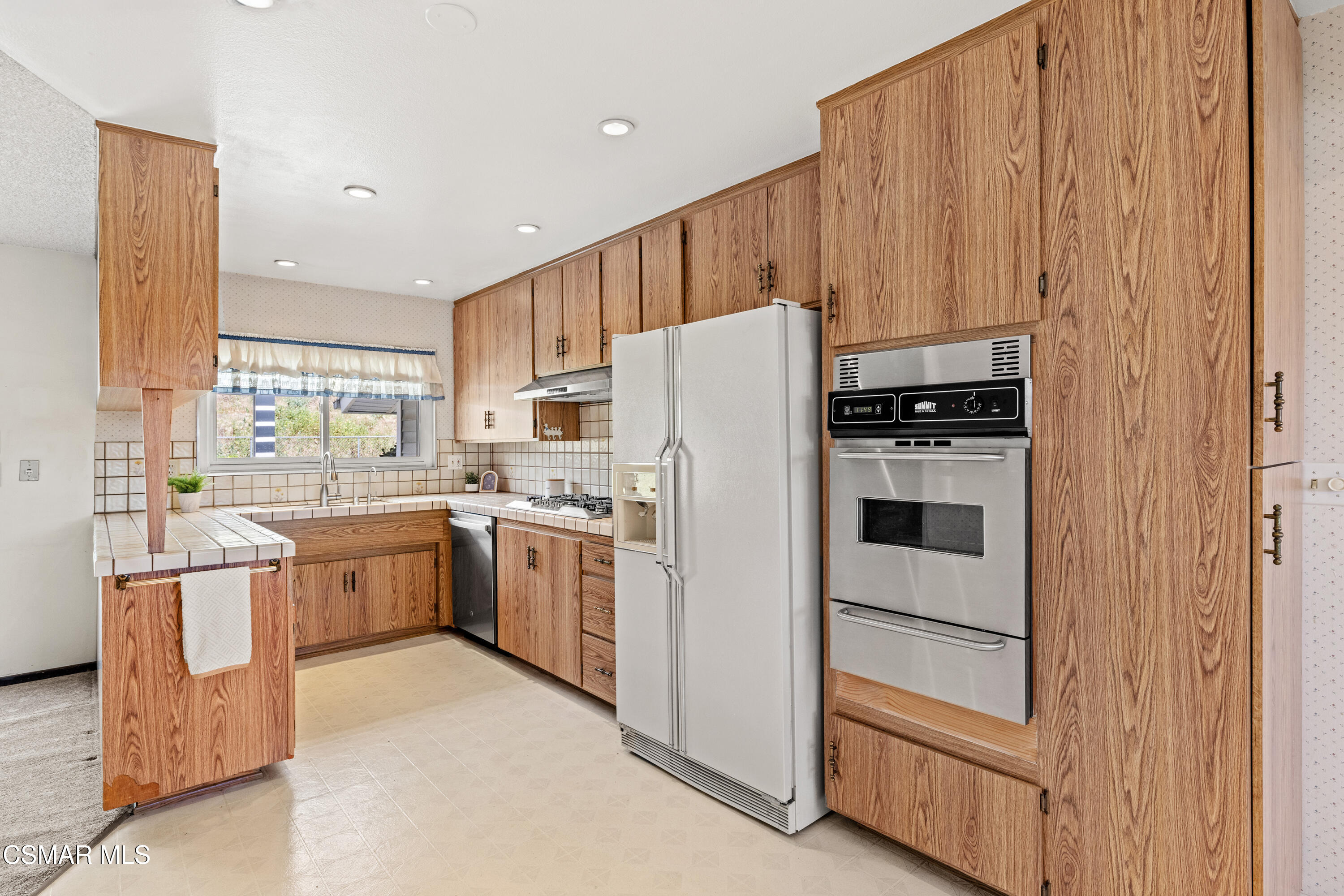 4477 Hempstead Street Simi Valley, CA 93063 - Photo 8 of 25 a kitchen with a refrigerator and a stove top oven