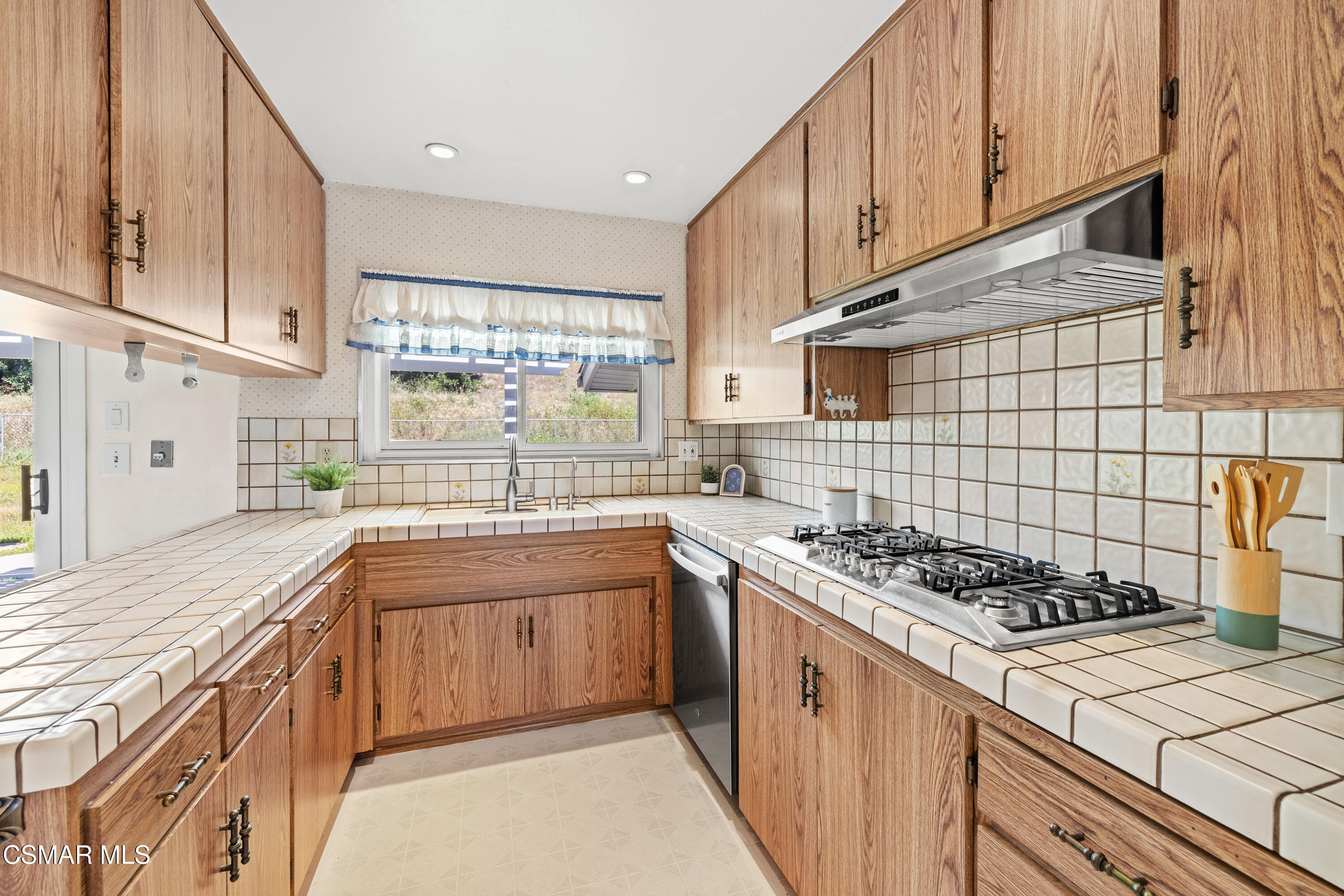 4477 Hempstead Street Simi Valley, CA 93063 - Photo 9 of 25 a kitchen with stainless steel appliances granite countertop a stove a sink dishwasher and cabinets with wooden floor