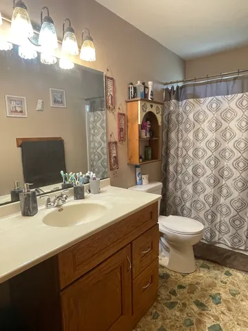 a bathroom with a sink vanity mirror and toilet