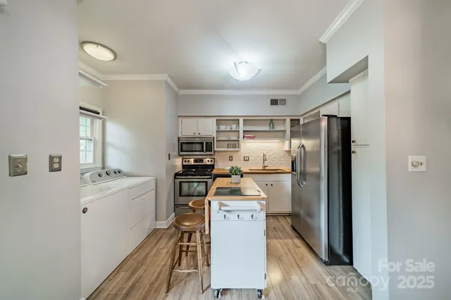 a kitchen with a refrigerator a stove top oven and cabinets