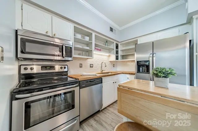 a kitchen with stainless steel appliances granite countertop a stove microwave and cabinets