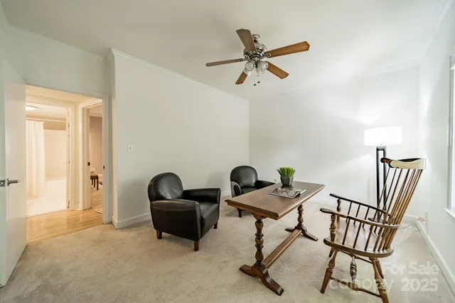a view of a workspace with furniture and a window