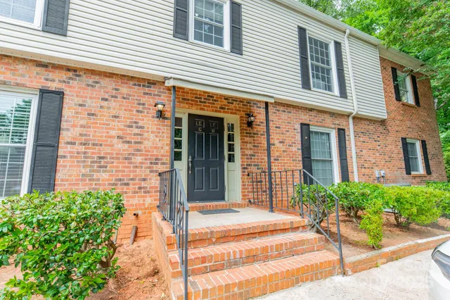 a view of a brick house with plants