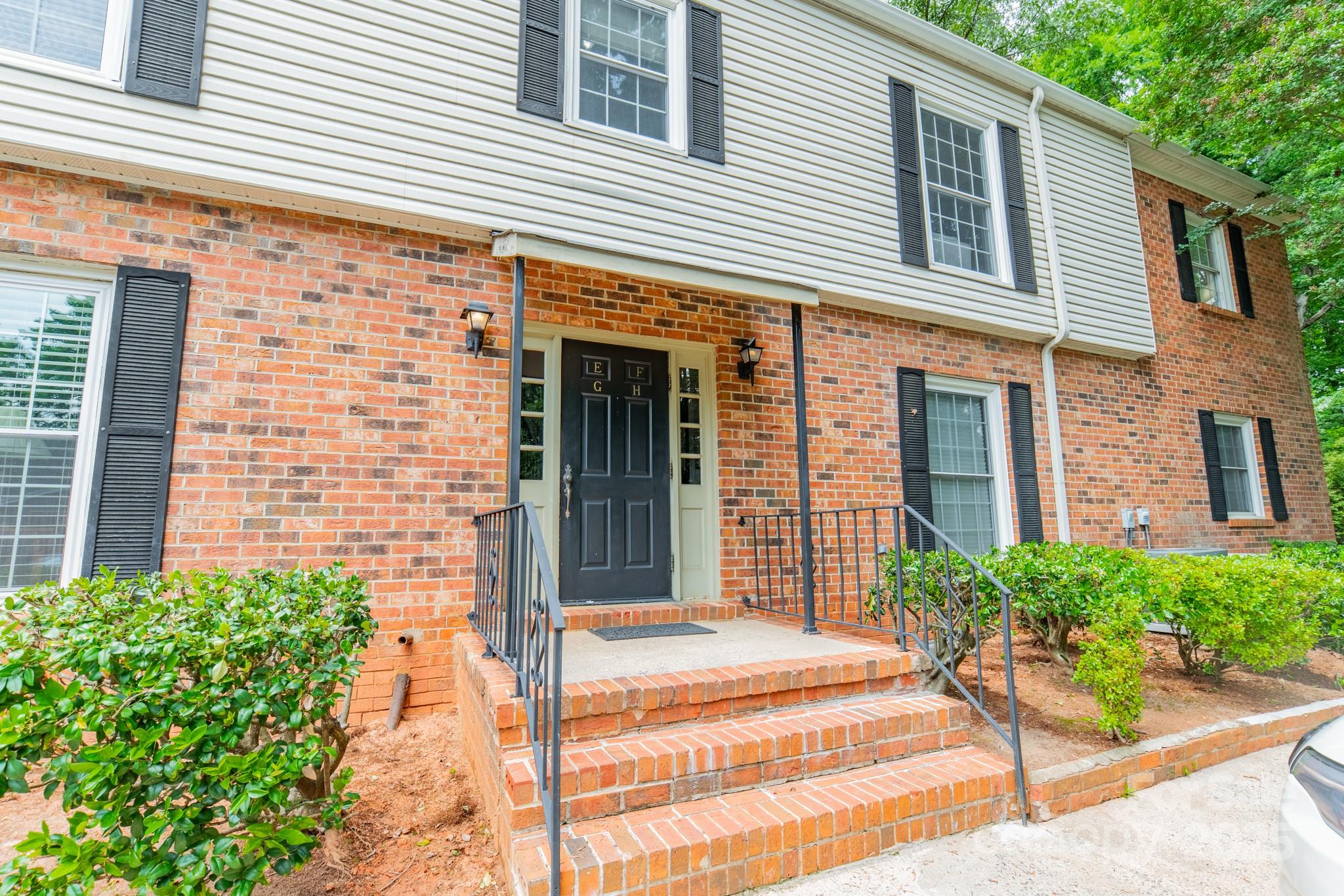 5927 Quail Hollow Road, Unit H Charlotte, NC 28210 - Photo 44 of 45 a view of a brick house with plants