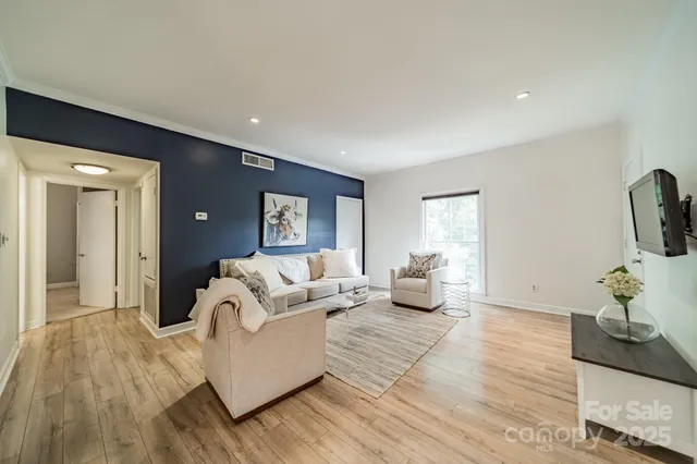 a living room with furniture and wooden floor
