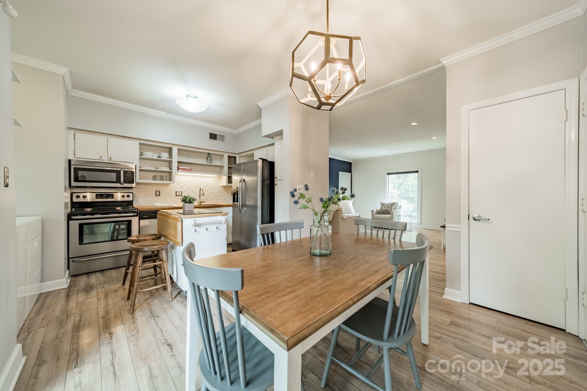 5927 Quail Hollow Road, Unit H Charlotte, NC 28210 - Photo 8 of 45 a view of a dining room with furniture a kitchen and chandelier