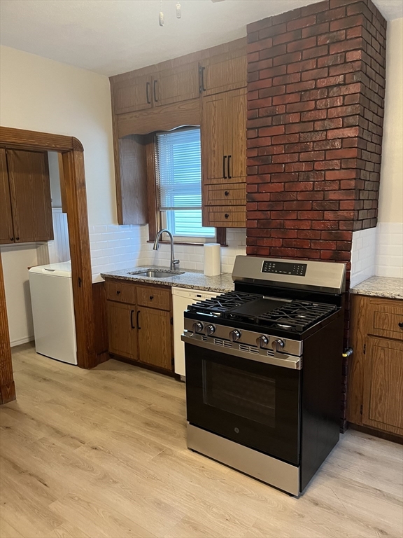 10 Antrim Street, Unit 2 Boston, MA 02128 - Photo 12 of 18 a kitchen with stainless steel appliances wooden cabinets and a stove top oven