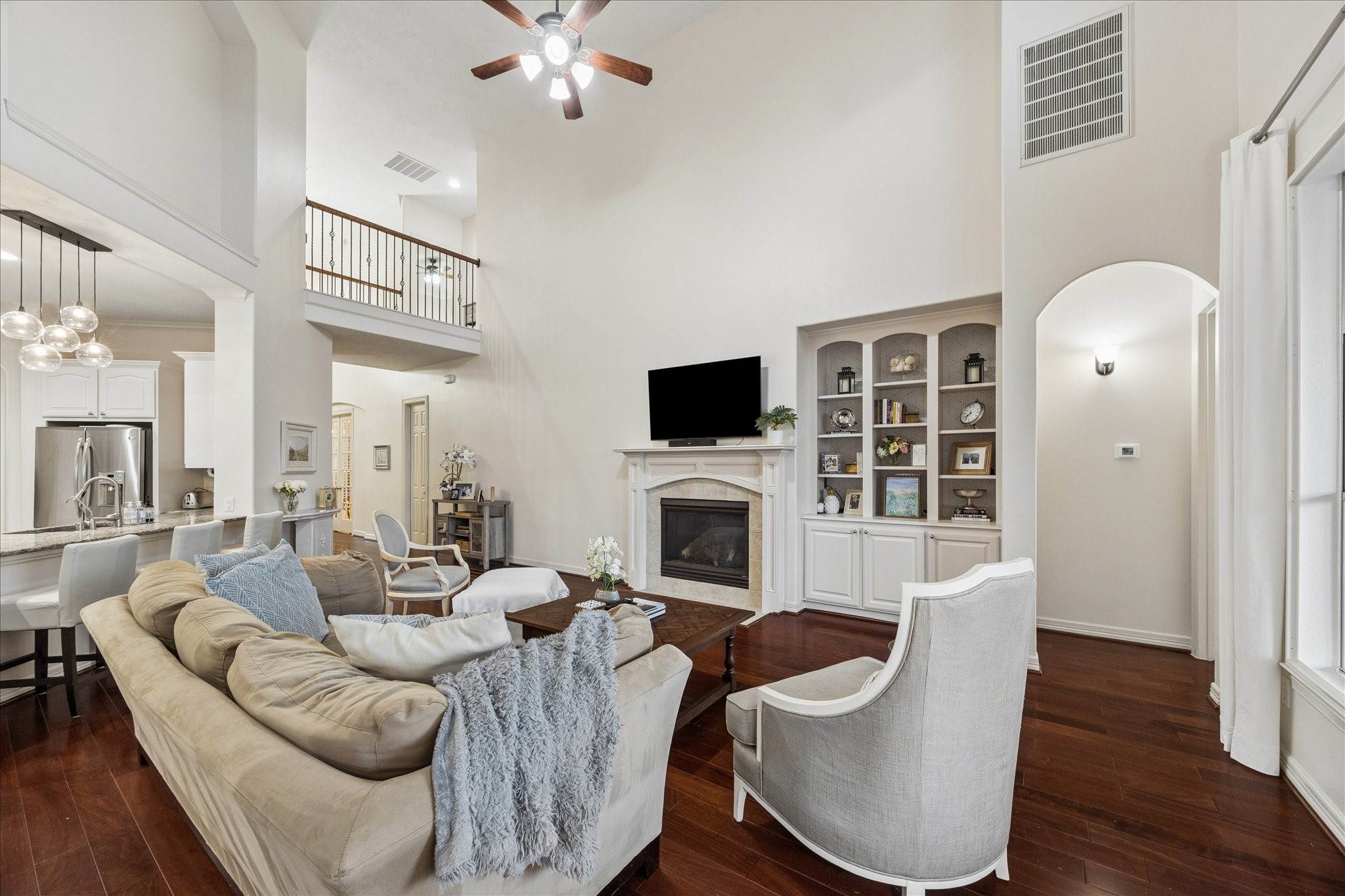 Open to the kitchen and breakfast room, the living room features high ceilings and large windows.