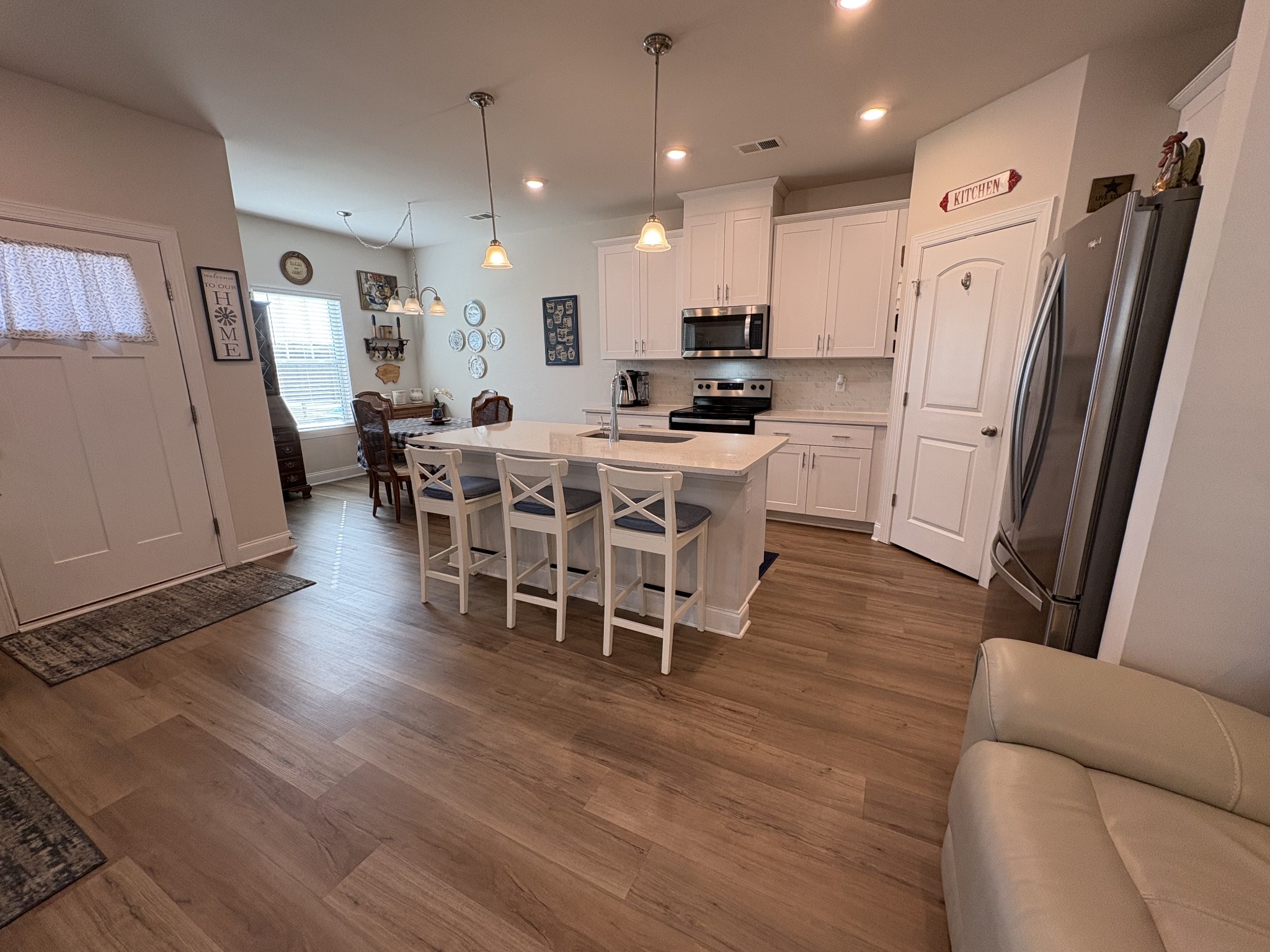672 Taylor Bend Columbia, TN 38401 - Photo 5 of 32 a kitchen with stainless steel appliances a refrigerator a stove a sink dishwasher with a dining table and chairs with wooden floor