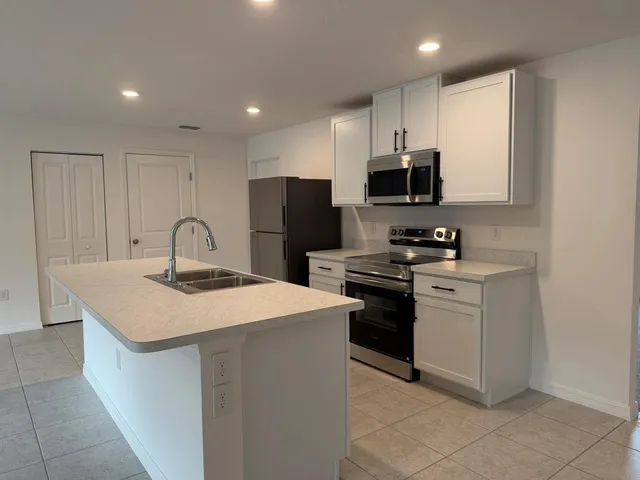 a kitchen with stainless steel appliances a refrigerator sink and stove