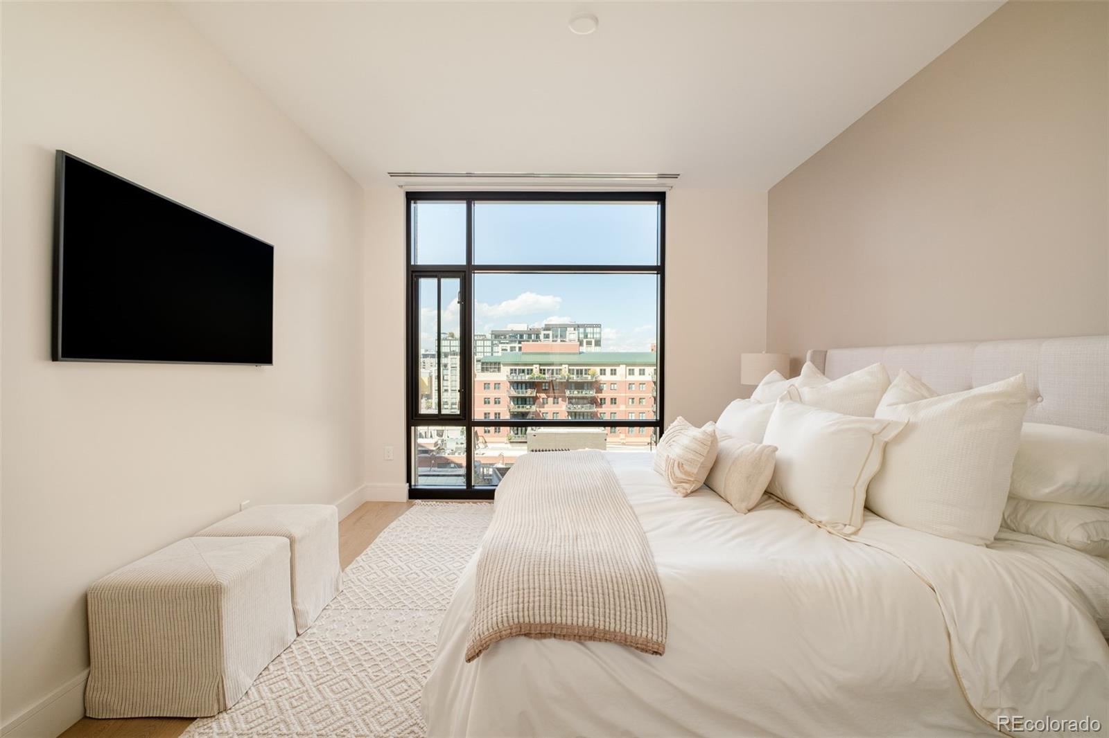 1901 Wazee Street, Unit 704 Denver, CO 80202 - Photo 15 of 49 a bedroom with a large bed and a flat screen tv