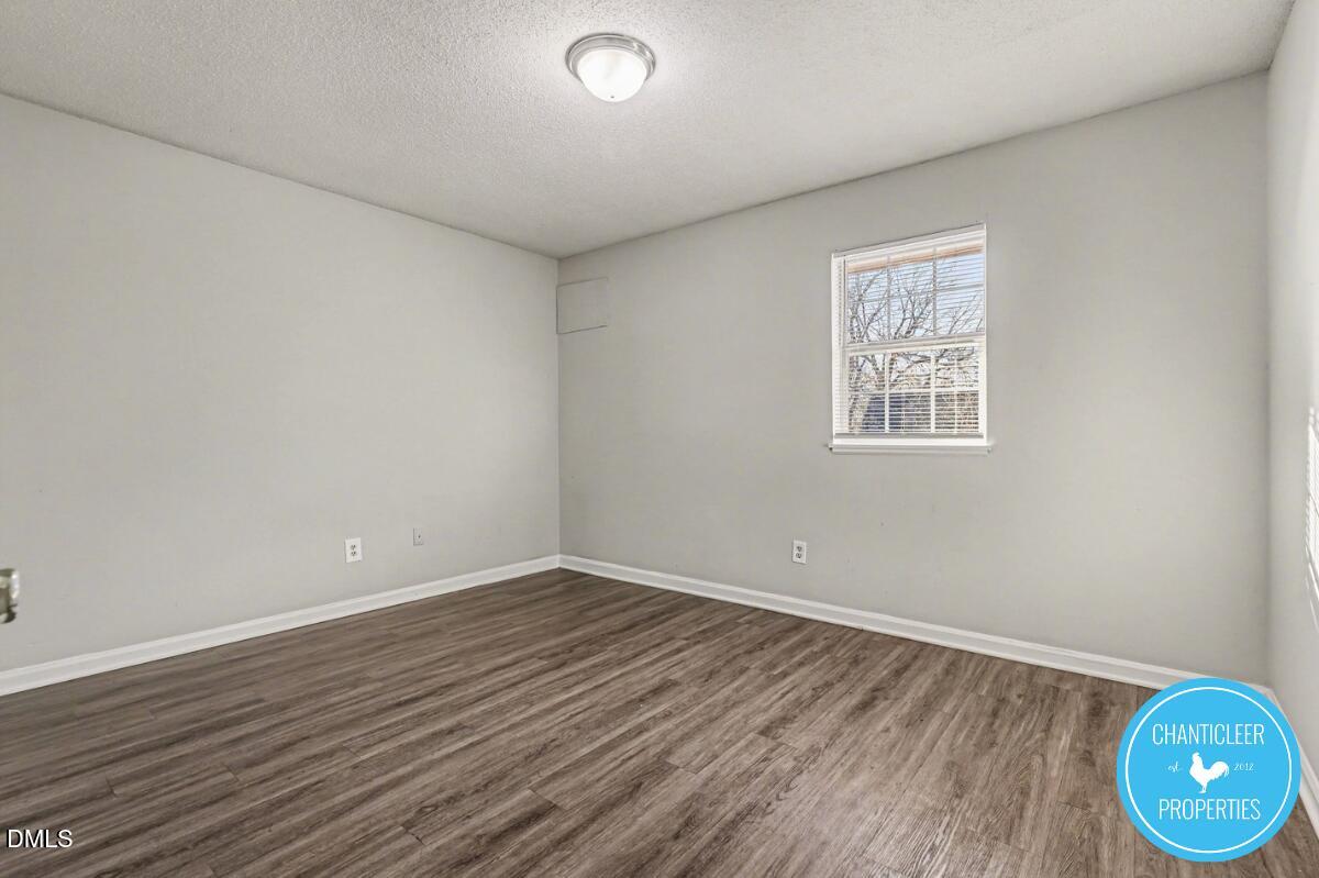 115 Florence Street, Unit 14 Graham, NC 27253 - Photo 12 of 29 an empty room with wooden floor and windows