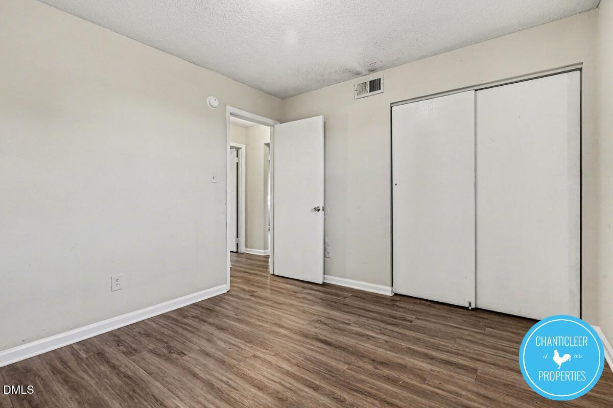 115 Florence Street, Unit 14 Graham, NC 27253 - Photo 16 of 29 a view of an empty room with wooden floor and a window