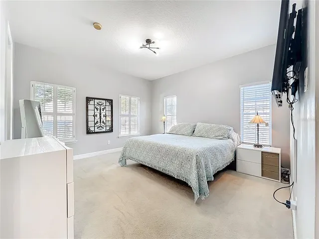 a spacious bedroom with a bed and a flat screen tv