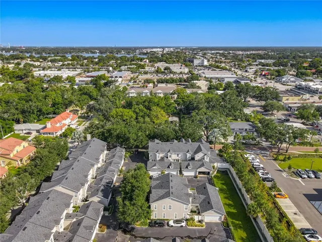 an aerial view of residential houses with outdoor space and ocean view