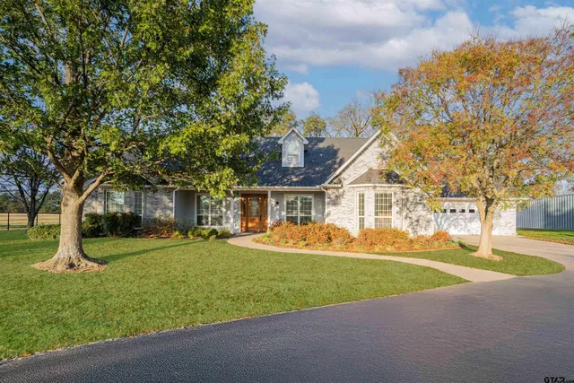 a view of a house with a big yard and large trees