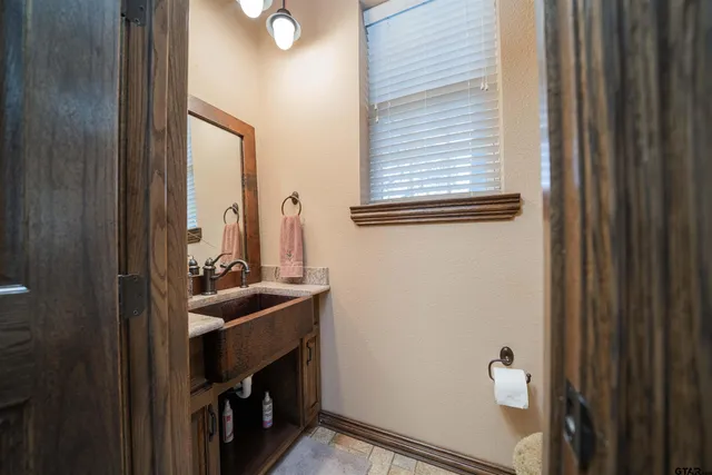a bathroom with a sink a toilet and a window