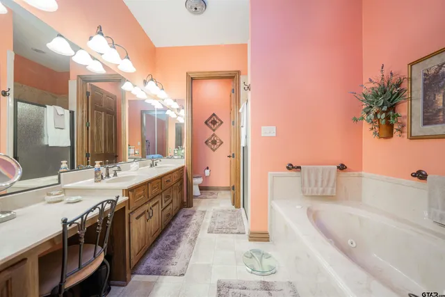 a spacious bathroom with a tub sink and mirror