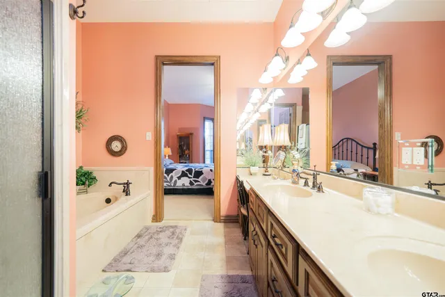 a large bathroom with a tub a double vanity sink and mirror