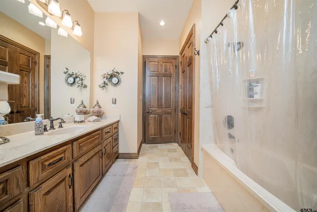 a bathroom with a double vanity sink a large mirror and shower