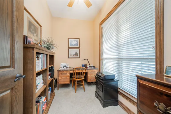 a view of a workspace with furniture and a window