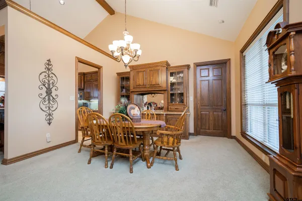 a view of a dining room with furniture and a chandelier