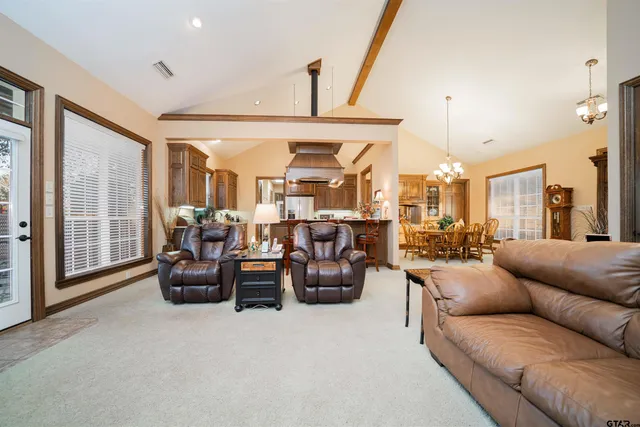 a living room with furniture kitchen view and a large window