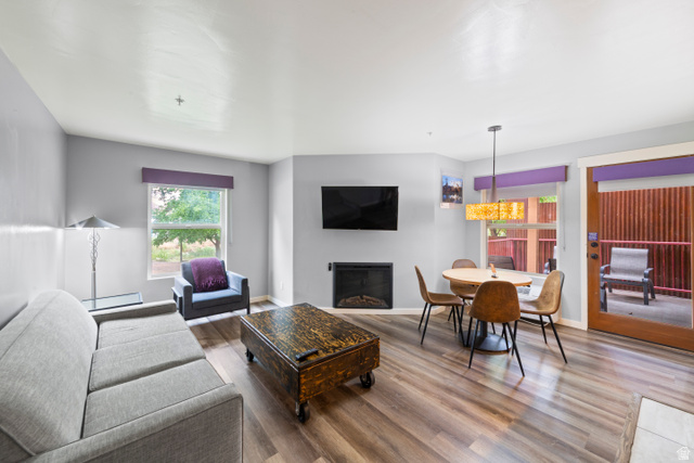 100 West 200 South, Unit 118 Moab, UT 84532 - Photo 11 of 39 Living room with wood finished floors, a glass covered fireplace, baseboard heating, and suspended lighting