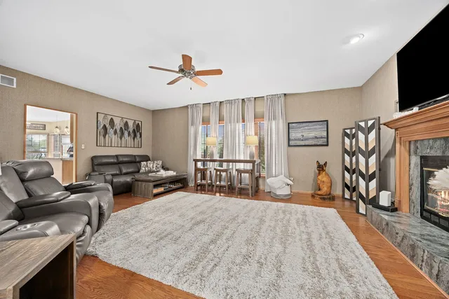 a living room with furniture a flat screen tv and a fireplace