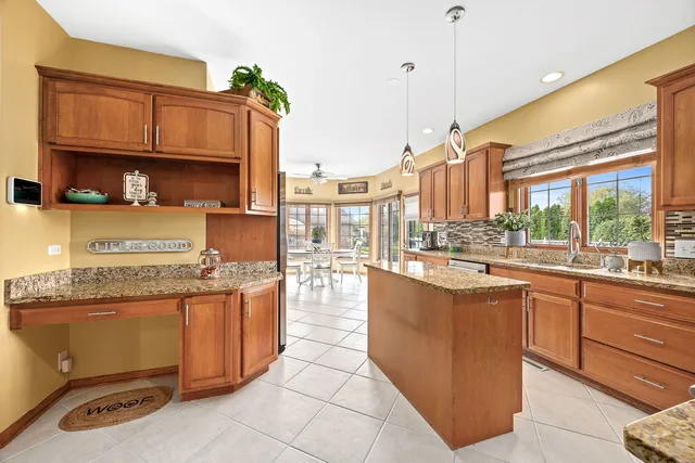 a kitchen with stainless steel appliances granite countertop a stove a sink and a microwave