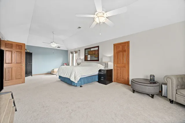 a spacious bedroom with a bed and a chandelier