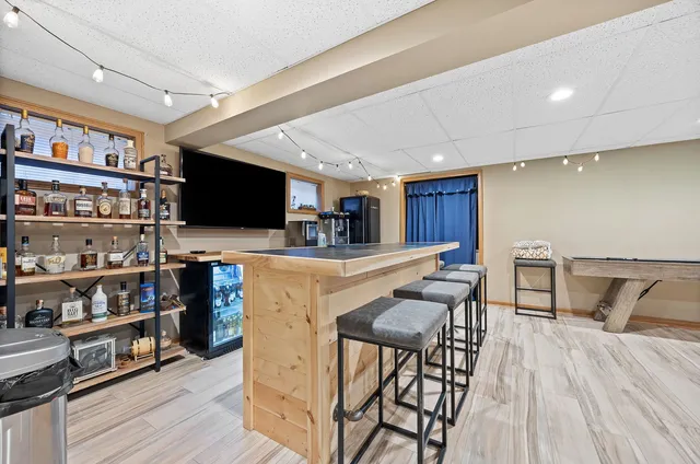 a kitchen with stainless steel appliances kitchen island granite countertop a table chairs refrigerator and a microwave