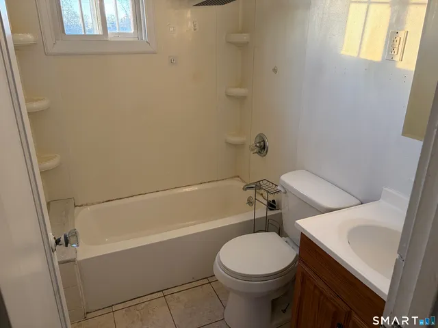 a white toilet sitting next to a bath tub