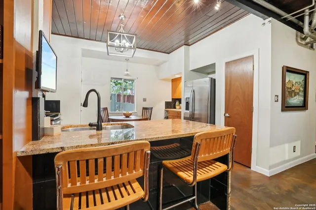 a view of a dining room with furniture a chandelier and wooden floor