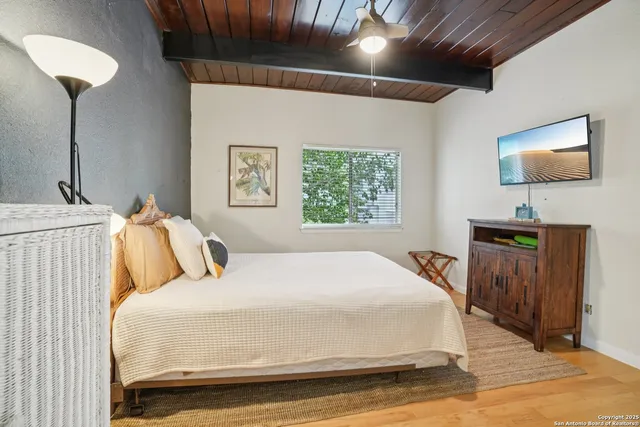 a bedroom with bed and a flat tv screen