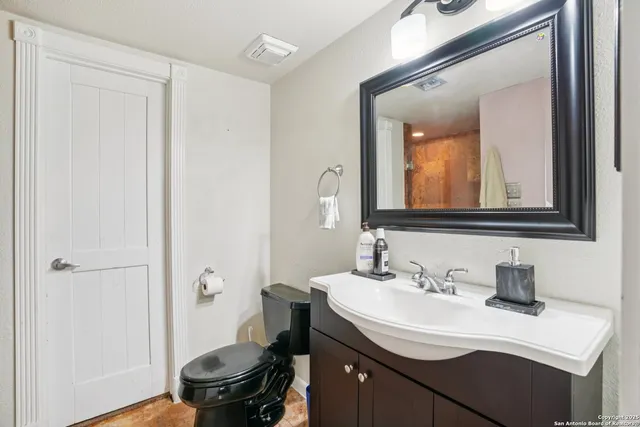 a bathroom with a sink toilet a mirror and vanity