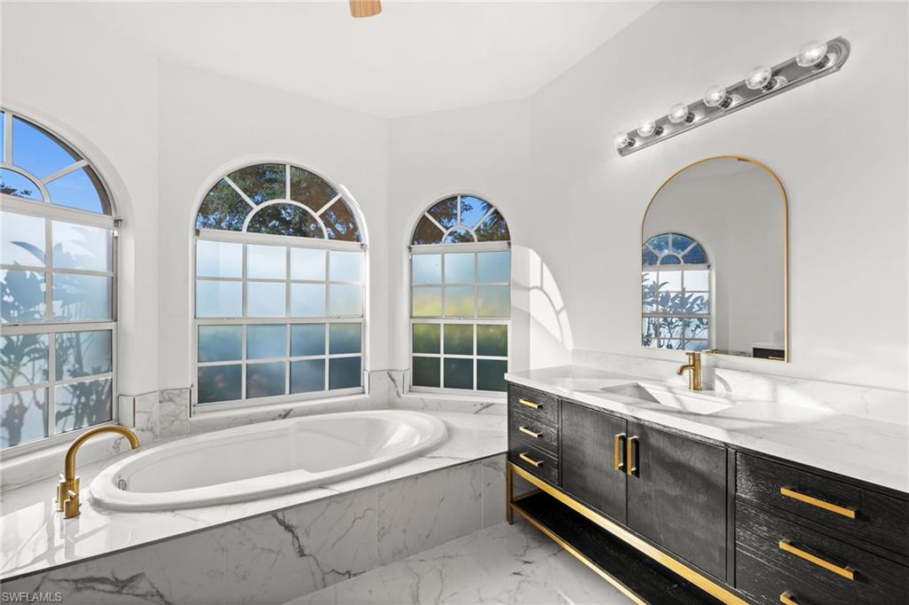 3972 Ruxton Road Naples, FL 34116 - Photo 20 of 41 a bathroom with a tub a sink and a large window